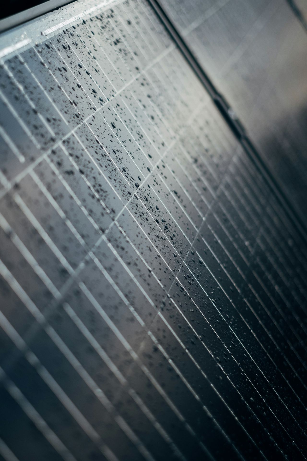 A close up of a tiled wall with water droplets